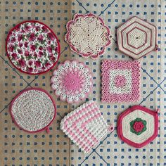 several crocheted coasters are arranged on a table