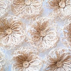 some brown and white flowers are on a blue table cloth with burlocked edges