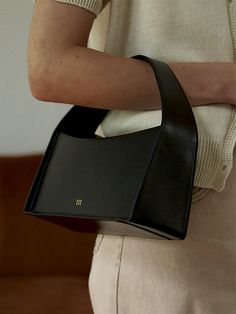 a woman carrying a black purse on her shoulder