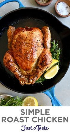 a roasting chicken in a skillet with lemons and herbs on the side