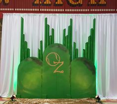 the stage is set up for an event with green and gold decorations on it, along with dr seussler's wizard wands