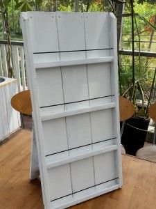 a white bookcase sitting on top of a wooden floor next to a potted plant