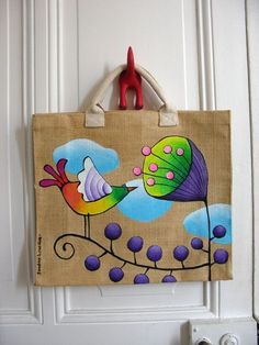 a bag hanging on a door handle with a bird painted on it