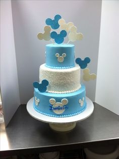 a three tiered cake with mickey mouse decorations