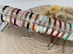 a bunch of bracelets that are sitting on a piece of wood