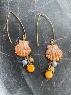 Sunset shell dangly earrings made with gold and pearls. Almost 3 inches long. One ear wire is damaged. Beautiful. Gold Beaded Dangle Earrings With Pearl Drop, Gold Dangle Beaded Earrings With Pearl Drop, Gold Shell Earrings With Pearl Charm, Gold Pearl Drop Earrings In Shell Shape, Gold Pearl Dangle Linear Earrings, Gold Pearl Earrings For Beach, Gold Wire Wrapped Dangle Linear Earrings, Gold Pearl Shell-shaped Earrings, Gold Dangle Linear Earrings With Pearl Charm