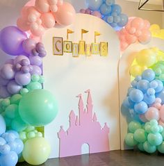 balloons are in front of a backdrop for a princess themed birthday party at the children's playroom