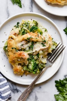 a white plate topped with chicken and broccoli casserole next to a fork