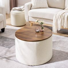 a living room with two white couches and a round coffee table in the middle