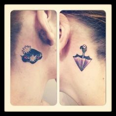 two tattoos on the back of their neck and behind them is an umbrella with flowers