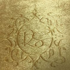 an ornate gold background with the word love written in cursive writing on it