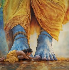 a woman laying on the ground with her feet painted blue and yellow, next to an elephant's legs