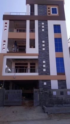 a tall white and brown building with blue windows