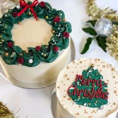 two cakes decorated with christmas decorations on top of a white tablecloth covered in tinsel