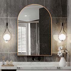 a bathroom with marble counter top and white sink under a large oval mirror above it