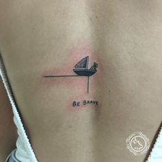 a person with a small boat tattoo on their back