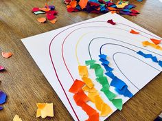 the paper is laid out on the table to make an art project for kids with colored papers