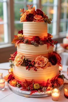 a three tiered wedding cake with flowers and candles