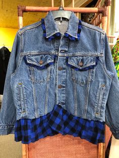 a blue jean jacket hanging on a clothes rack