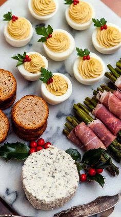 an assortment of appetizers are arranged on a marble platter with asparagus and deviled eggs