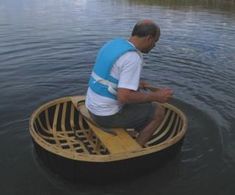 a man sitting on top of a wooden boat in the water