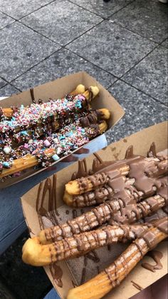 two boxes filled with different kinds of donuts and chocolate covered pretzel sticks