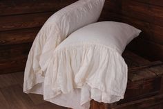 a bed with two pillows on top of it next to a wooden wall and floor