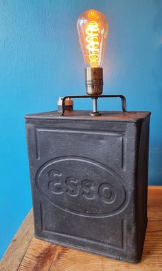 an old fashioned light bulb sitting on top of a metal box with the word osss printed on it