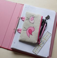 an open notebook with pens and scissors on it