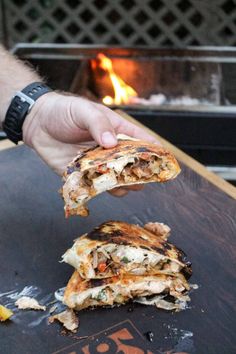 a person is about to grab some food out of the fire pit with their hand