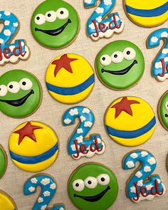 decorated cookies with numbers and faces are displayed on a table