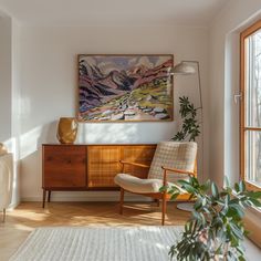 a living room with a painting on the wall and a chair in front of it