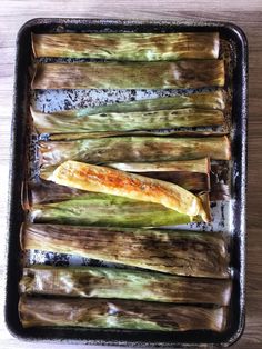 an uncooked vegetable is sitting in a baking pan on a wooden table, ready to be cooked