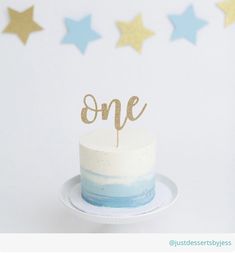 a cake with the word one on it sitting on a plate in front of stars