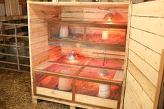 the inside of a chicken coop with two lights on and some hay in front of it