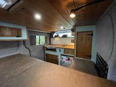 the interior of an rv with wood paneling and cabinets on the walls is shown