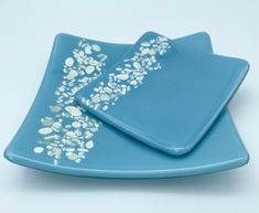 two blue plates with white designs on them