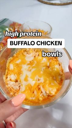 a person holding a bowl of food with the words high protein buffalo bowls above it