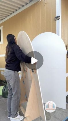 a woman standing next to a white surfboard