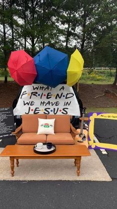 a couch with an umbrella on top of it in the middle of a parking lot