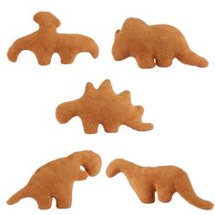 four dinosaur shaped cookies are shown on a white background, including one is brown and the other is orange