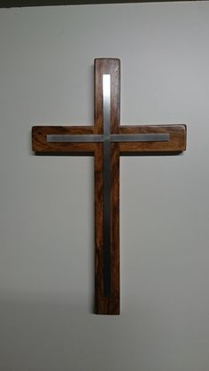 a wooden cross hanging on the wall with a light shining in it's center