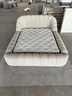 an inflatable mattress is on display at a furniture store with chairs and tables behind it