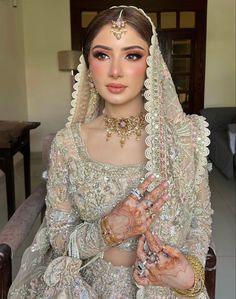 a woman in a bridal gown with flowers on her head and jewelry around her neck