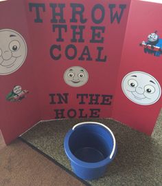 there is a red book with cartoon faces on it and a blue bucket in front of it