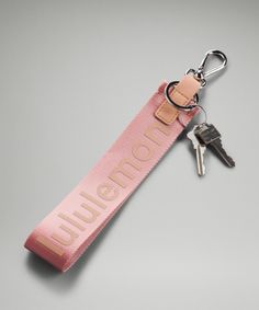 a pink keychain with the word burton on it and two keys attached to it