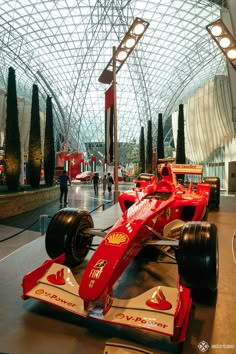 a red race car is on display in a museum