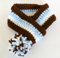 a crocheted scarf with a pom - pom on it