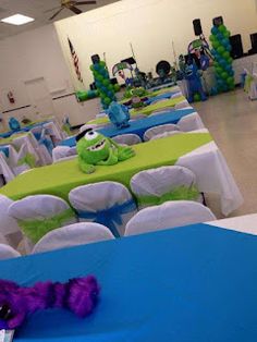 a room filled with tables covered in blue and green tablecloths