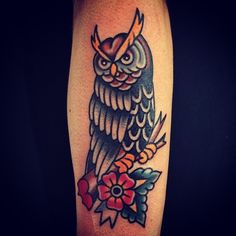 an owl with horns and flowers on its arm